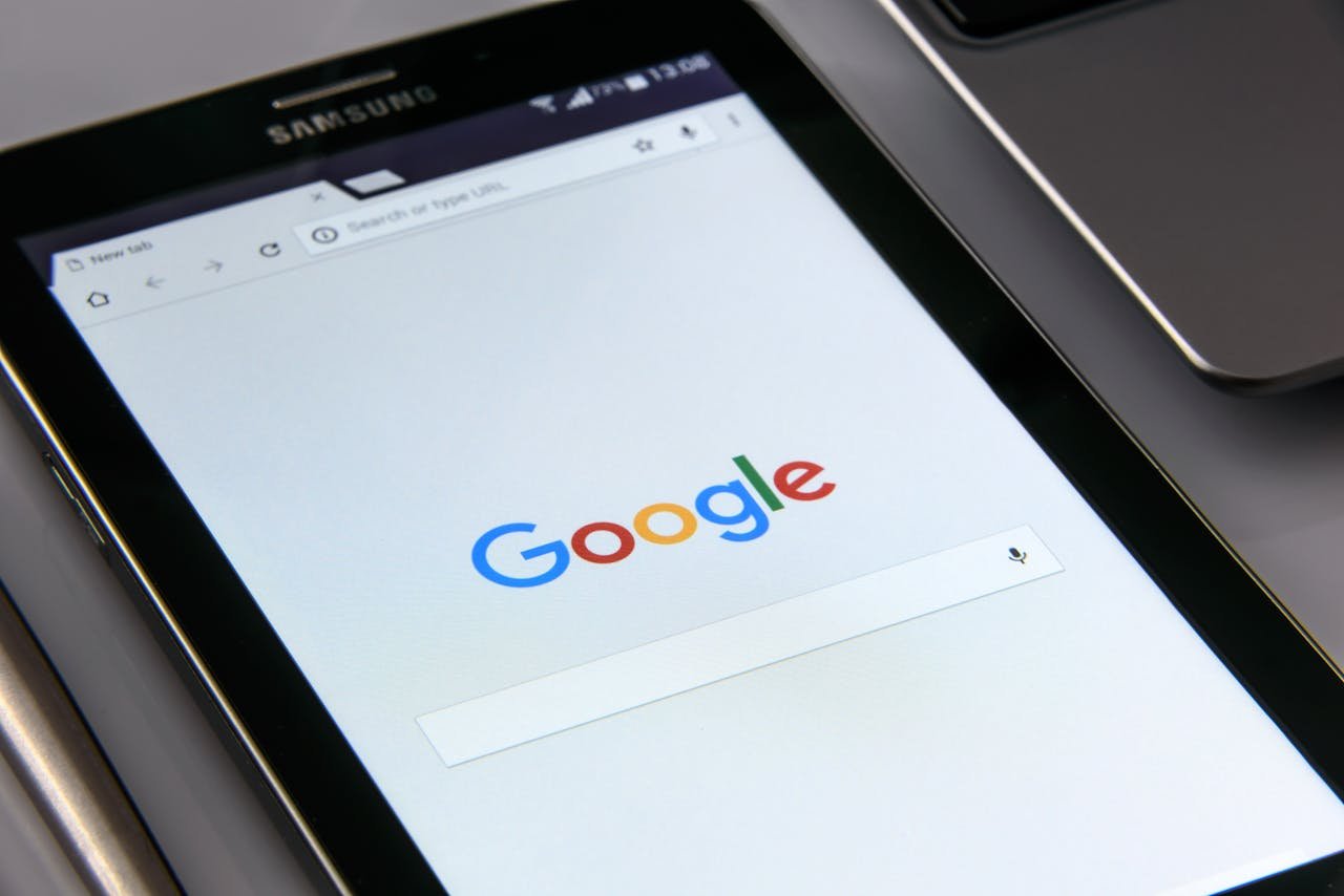 services-02 Close-up of a tablet displaying Googles search screen, emphasizing technology and internet browsing.